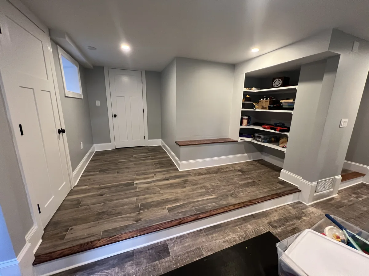 Built-in shelving and bench in a finished basement by DeFaria Construction