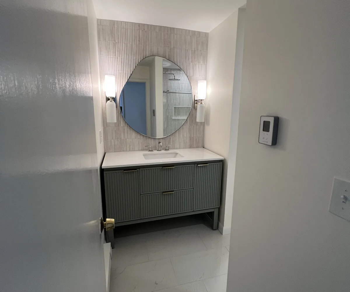 Bathroom remodel by DeFaria Construction with fluted vanity and tile accent wall