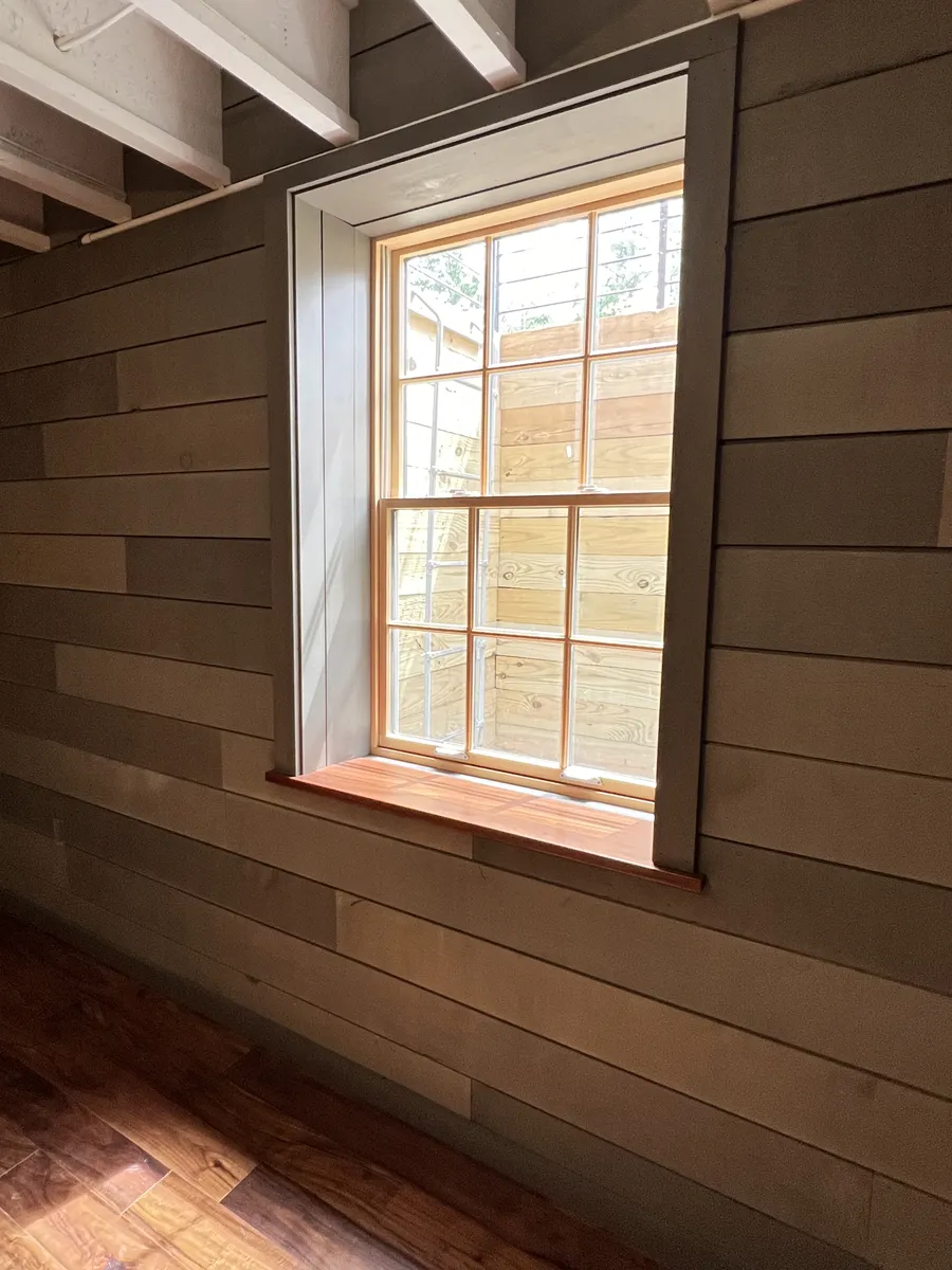 Window casing and wood stool on a shiplap wall by DeFaria Construction