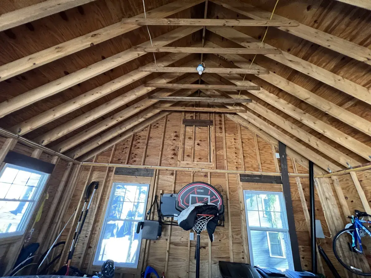 Exposed roof framing and rafters before insulation in a DeFaria Construction structural remodel, framing contractors in Massachusetts