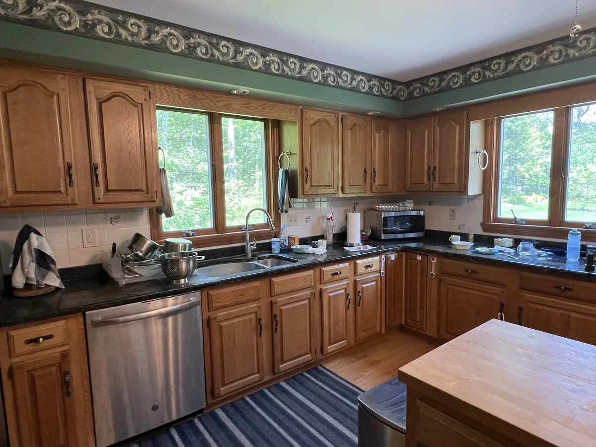 Dated kitchen with oak cabinets and dark counters before a DeFaria Construction remodel