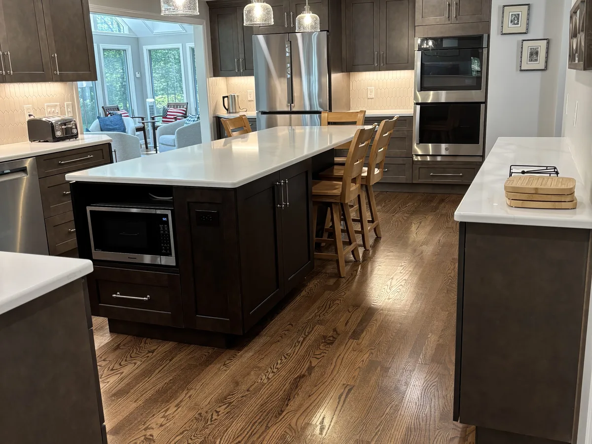 Remodeled kitchen with large island, wall ovens and wood floors by DeFaria Construction