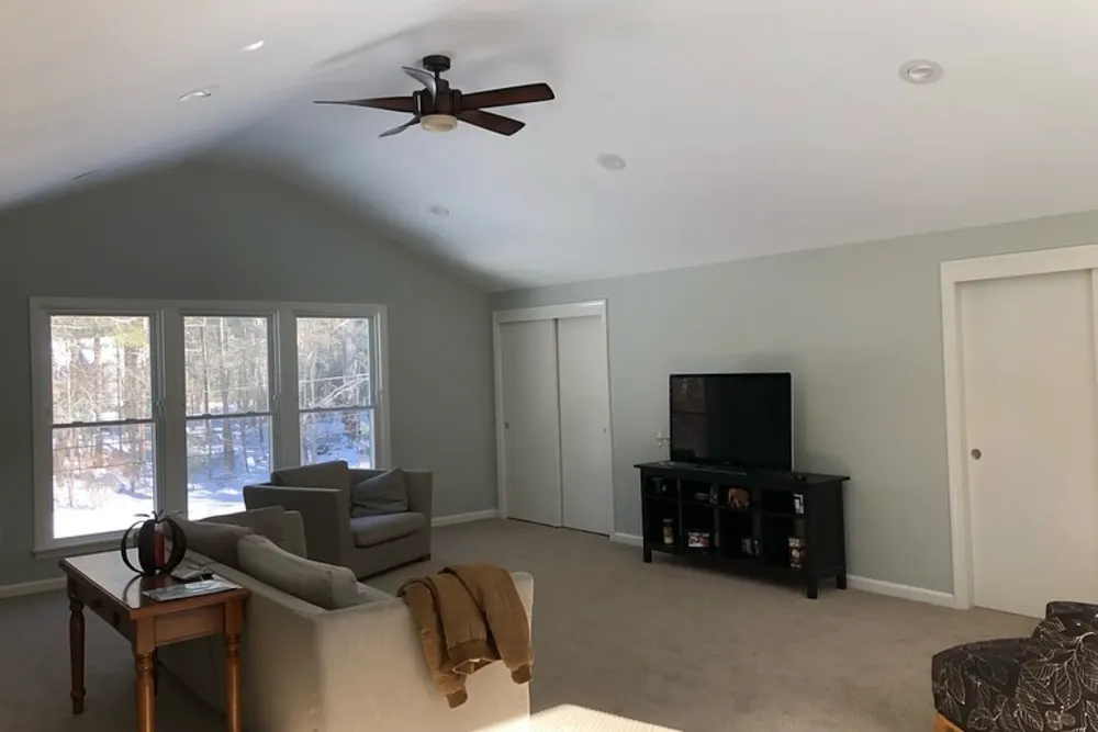 New bonus room above the garage with large windows and carpet in Groton, MA, by DeFaria Construction