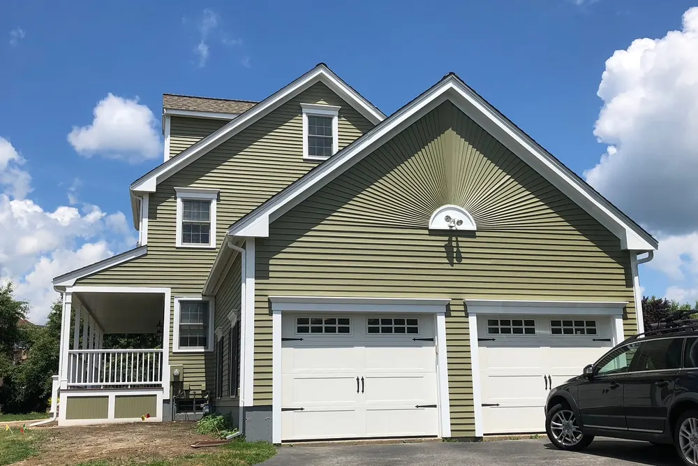 Repainted home exterior with new trim around the garage and gable, DeFaria Construction