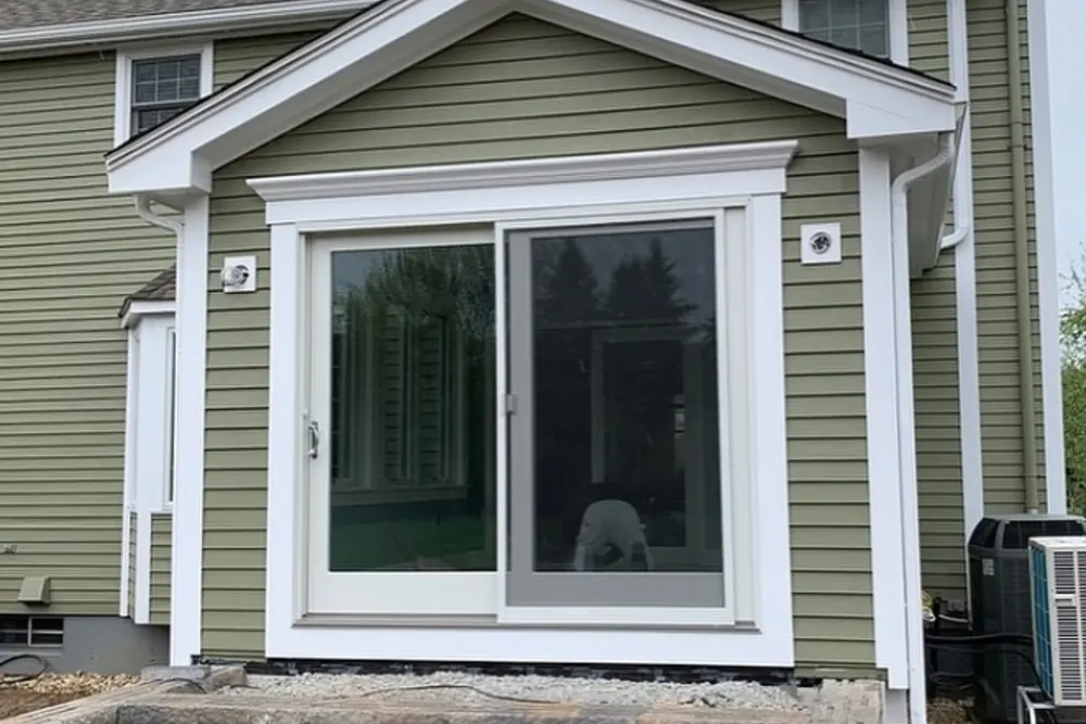 New exterior trim and pediment around a sliding patio door by DeFaria Construction